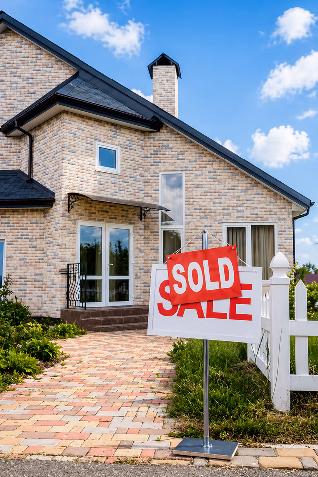 A recently sold single-family home with a Sold sign out front.